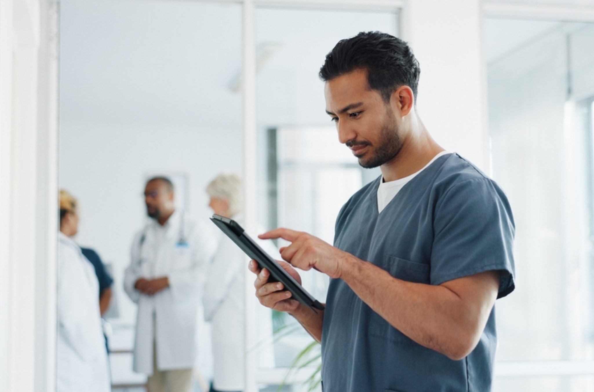 Male nurse employee looking at a workforce scheduling interface with team shifts and calendars, representing employee scheduling
