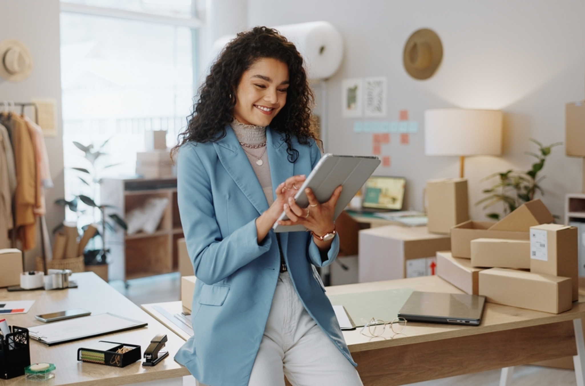 A woman entrepreneur looking at a scheduling interface on her tablet, representing scheduling software for small business